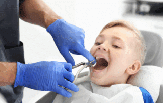a child opening his mouth wide at the orthodontist, representing early orthodontic evaluation